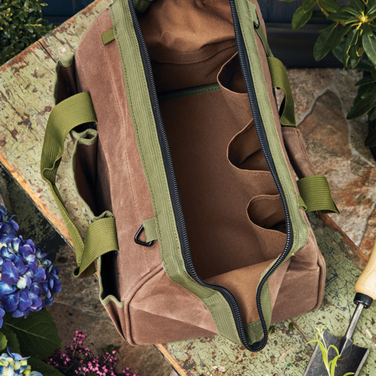 An open Garrett Wade waxed-canvas garden tool bag with internal pockets.